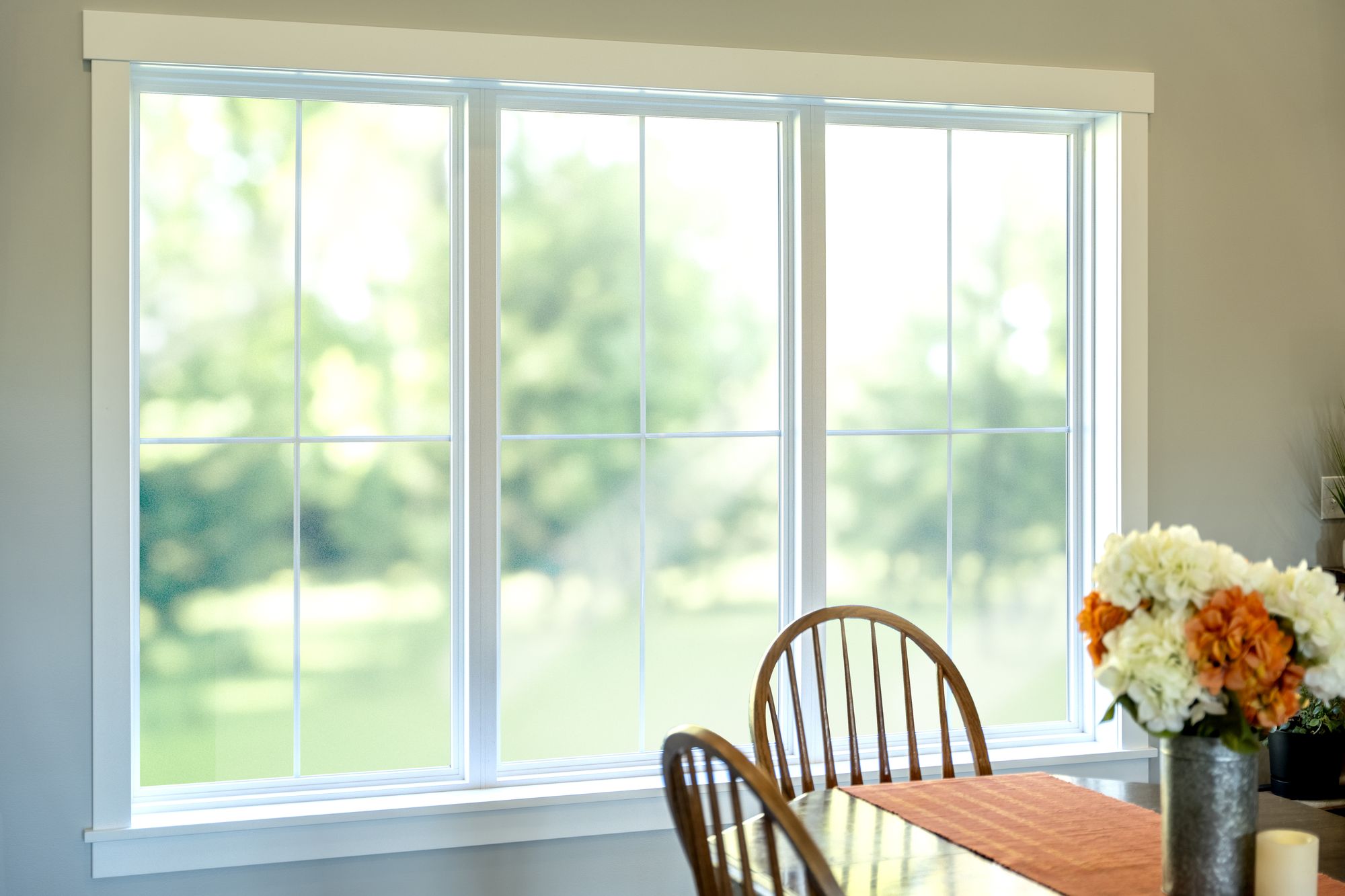White casement replacement windows over a dining table